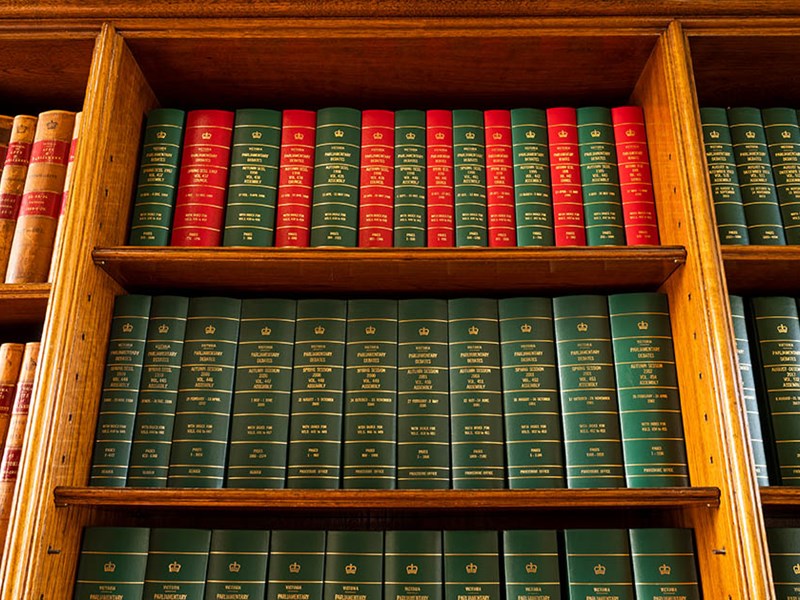 A bookshelf filled with leather-bound tomes.